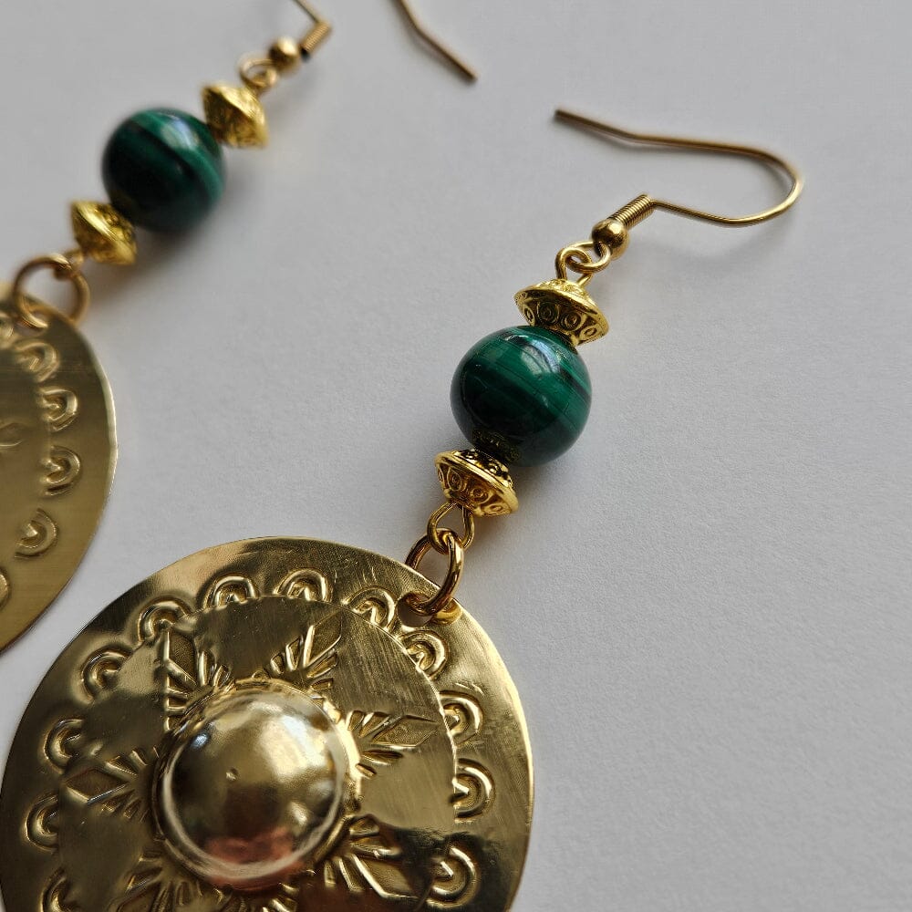 
                  
                    Brass agong medallions, malachite beads, gold tone conical motif design beads, gold-plated stainless steel ear wire and findings.
                  
                