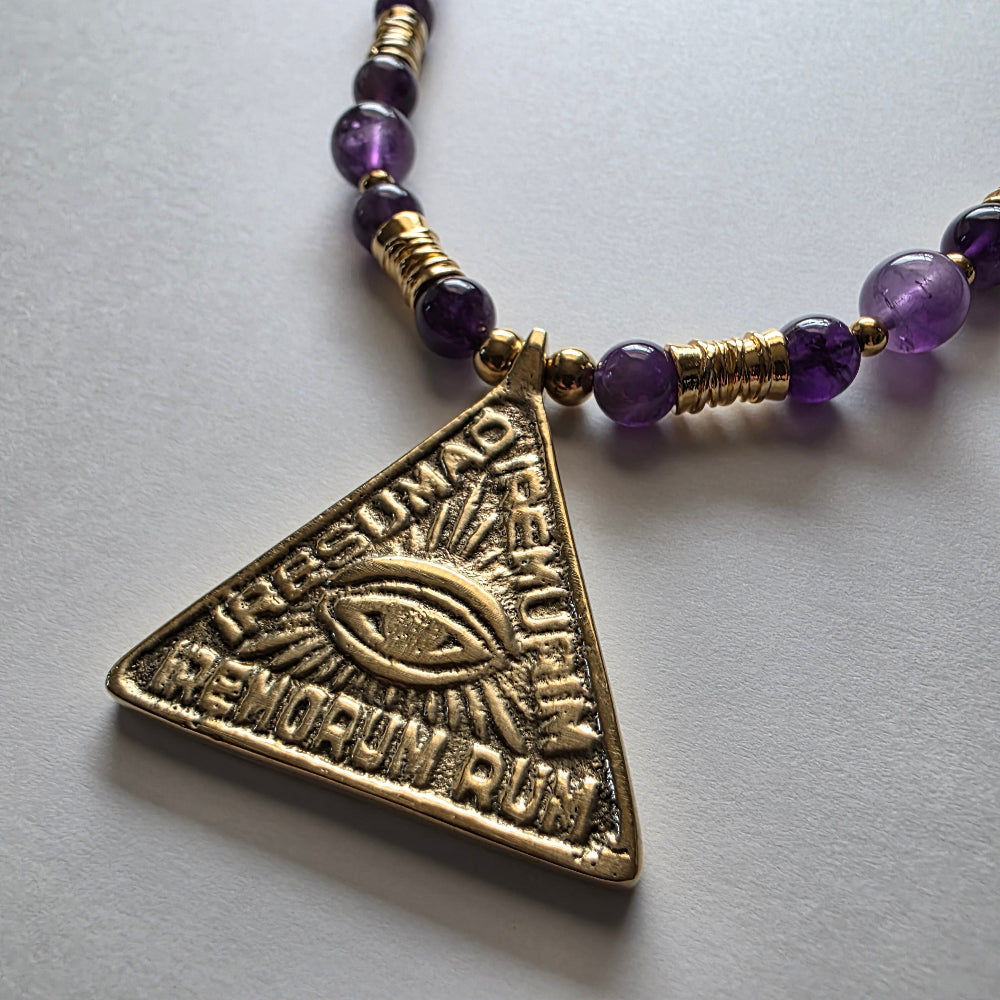 Necklace with a triangular pendant featuring an eye design on a light gray background