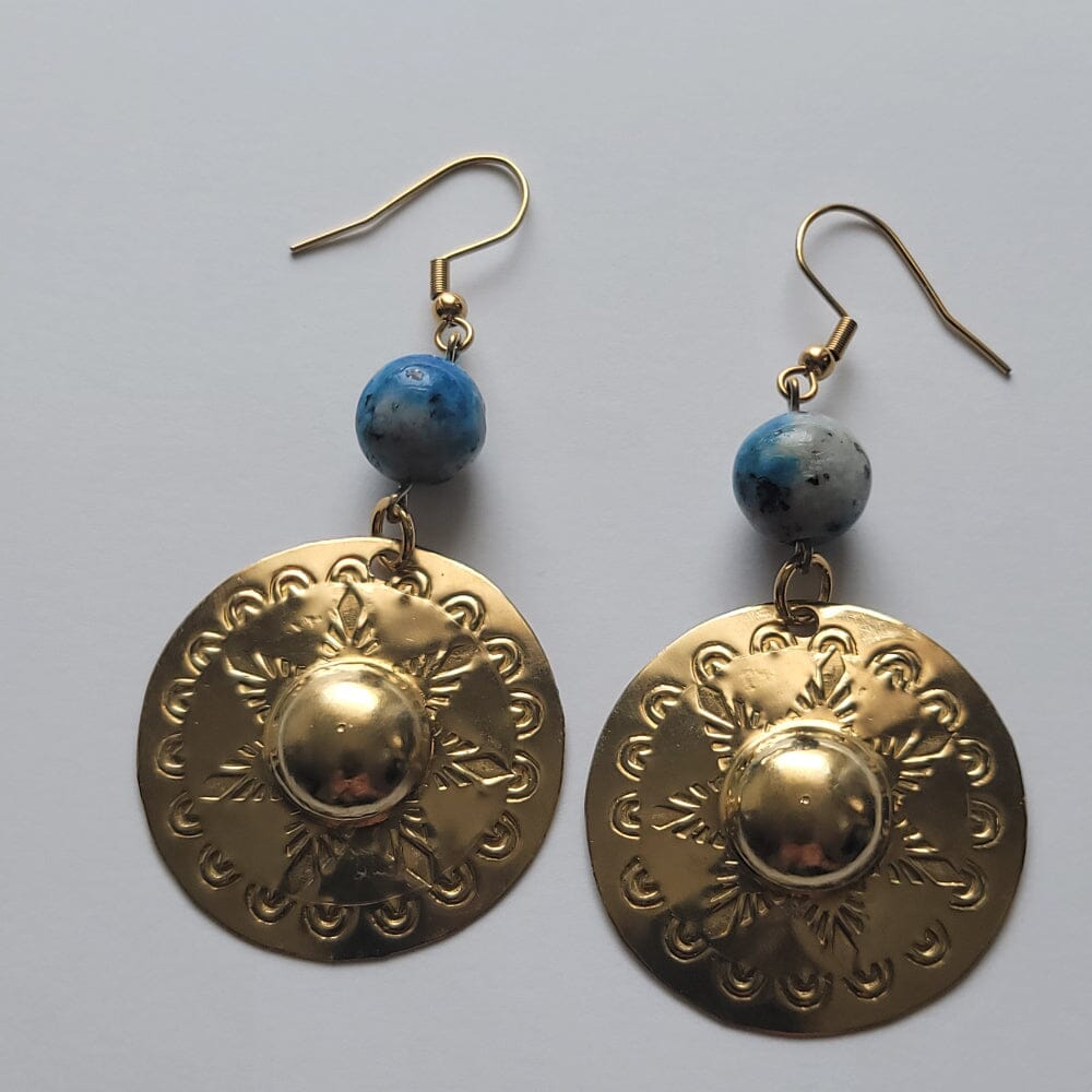 Gold earrings with blue beads on a gray background