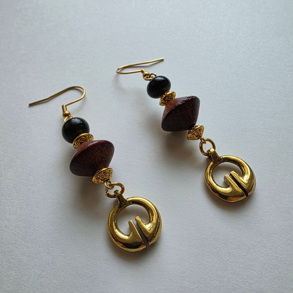 Pair of earrings with gold and brown beads on a light gray background