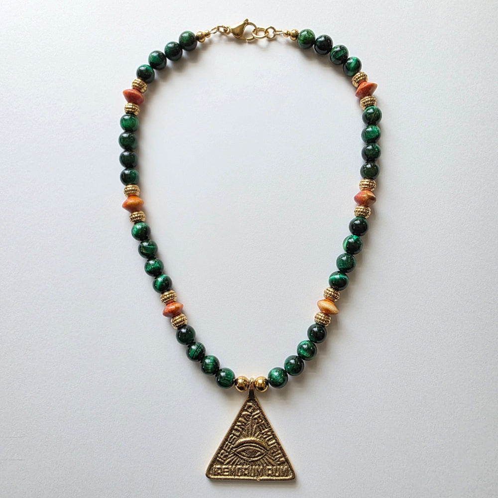 Necklace with green beads and a gold pyramid pendant on a white background