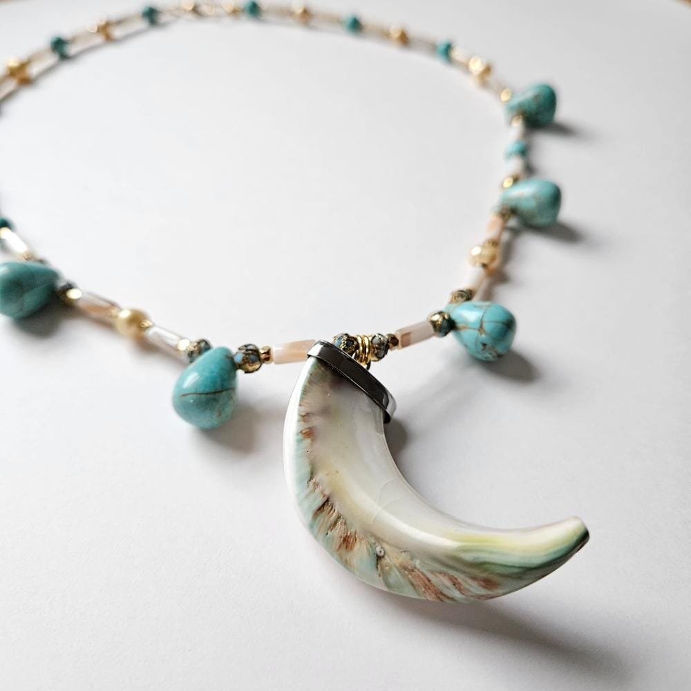 Detail of rare giant green banded turbo marmoratus pendant, with dyed turquoise howlite teardrop beads with cloisonne, gold colored metal faceted spacers. mother-of-pearl tube beads and golden freshwater pearls from the Philippines.