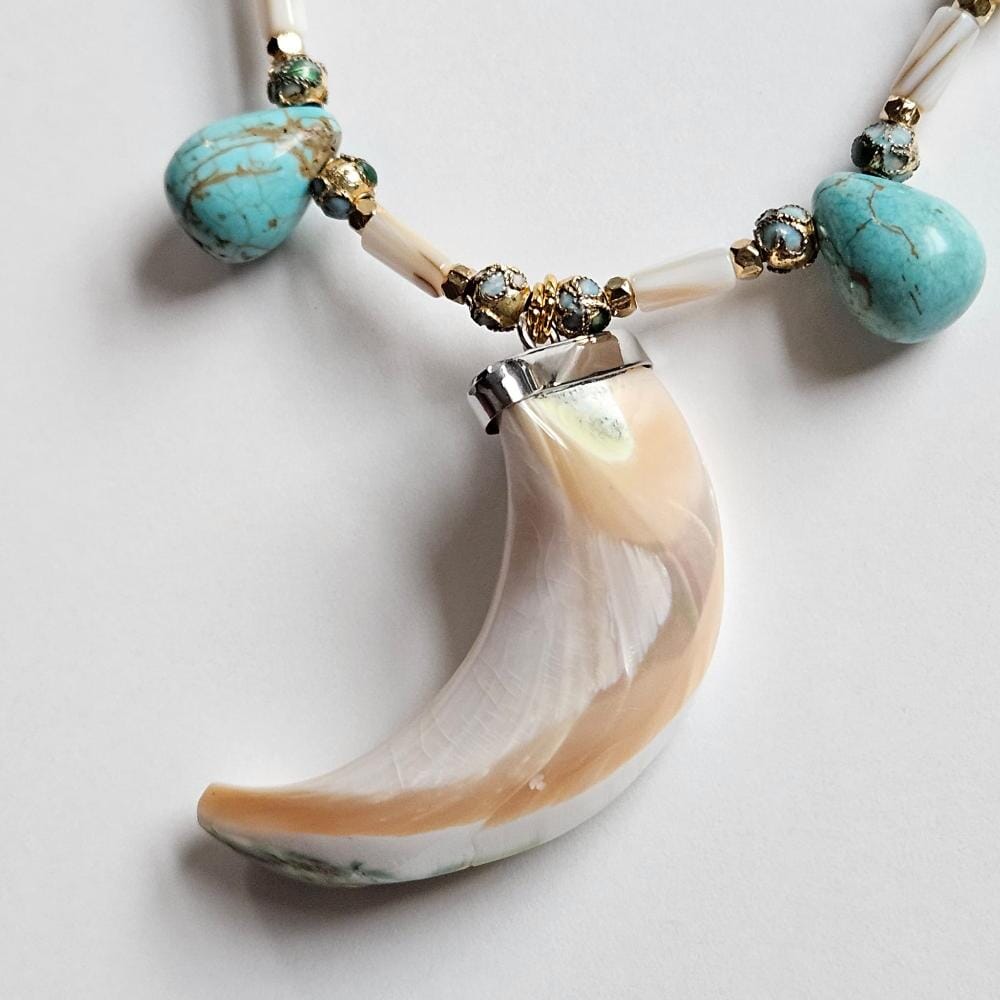 
                  
                    Rare giant green-banded turbo marmoratus shell tusk pendant sourced from the Philippines with cloisonne, mother-of-pearl tube beads and dyed turquoise howlite teardrop beads.
                  
                